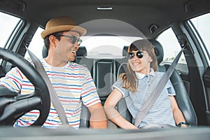 Front view of Funny moment couple asian man and woman sitting in car. Enjoying travel concept.