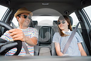 Front view of Funny moment couple asian man and woman sitting in car. Enjoying travel concept.