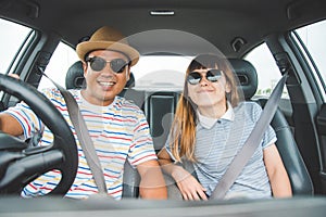 Front view of Funny moment couple asian man and woman sitting in car. Enjoying travel concept.