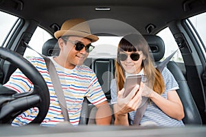 Front view of Funny moment couple asian man and woman sitting in car. Enjoying travel concept.