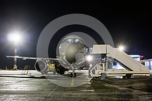 Front view of ground handling passenger airplane at night