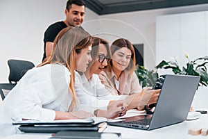 Front view of group of business people in formal clothes working indoors in the office