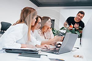 Front view of group of business people in formal clothes working indoors in the office