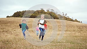 Front View Of Group Of Children On Outdoor Activity Camping Trip Running Down Hill