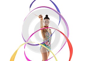 Front view. Half size portrait of young female rhythmic gymnast practicing with colored ribbon isolated on white