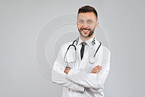 Smiling doctor with strethoscope isolated on grey.