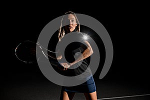 front view of handsome woman tennis player with brown hair in black uniform with tennis racket