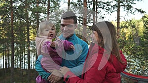 Front view of happy american family with kid having time in autumn forest.