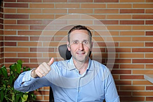 Front view of happy businessman doing the ok gesture with the thumb up