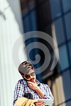 Front view of a happy man calling on the phone walking on the street