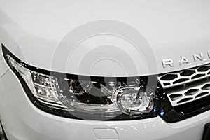 Front view headlight of a white Land Rover Range Rover Sport 2017. Car exterior details.