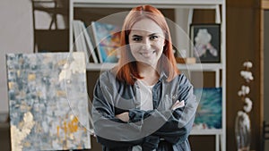 Front view headshot close up Caucasian smiling toothy happy painter woman art girl hipster lady with red hair looking at