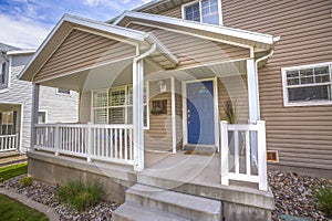 Front view of a home with cozy porch and glass paned bright blue front door