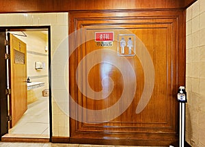 Front view of hotel restroom or toilet with man and women signs on wooden wall photo