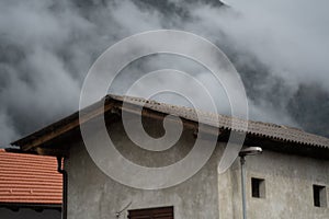 Front view of houses in Kanal, Slovenia with clouds and mountains in the background