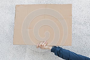 Front view of human holding carton placard with space for inscription, stop racism strike, protesting for defund police, hand with photo