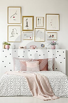 Front view of a king size bed with pink pillows, dotted sheets,
