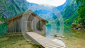 front view of lakeside cabin or traditional wooden boat house in Obersee on the left with a peaceful and clear lake on a