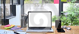 Laptop computer with blank screen on creative workspace.