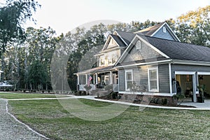 Front view of a large two story blue gray house with wood and vinyl siding