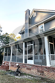 Front view of a large two story blue gray house with wood and vinyl siding