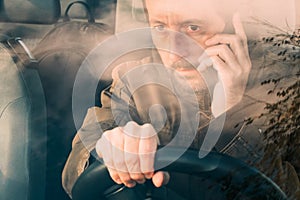 Front view of man driving car and talking on mobile