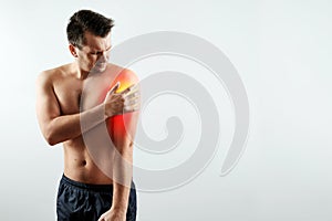 Front view, the man holds his hands to the forearm, pain in his hand, pain in the shoulder highlighted in red.