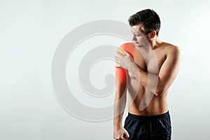 Front view, the man holds his hands to the forearm, pain in his hand, pain in the shoulder highlighted in red.