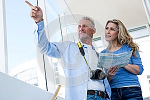 Front view of mature couple holding map