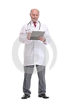 Front view of mature serious doctor writing on clipboard