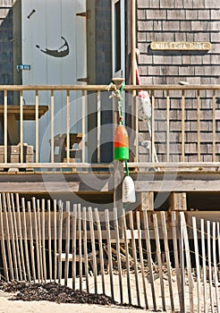 Beach front cottage with storm fence and crab buoy photo