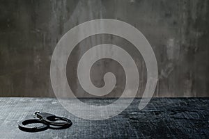 Front view of metal handcuffs on table in interrogation room photo