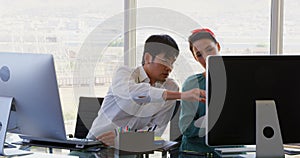 Front view of Mixed-race Business people discussing over computer at desk in office 4k