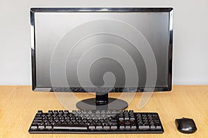 Front view of a Modern Desktop Computer Setup with Monitor, Keyboard, and Mouse on a Desk
