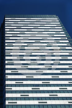 Front view of modern glass and concrete exterior of high rise building as abstract urban background, geometric pattern