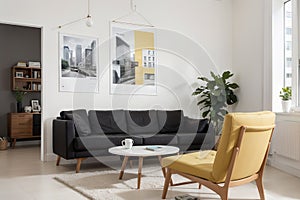 Front view of modern living room interior with one empty poster on white wall, mock up. Furnished by yellow armchair, coffee table