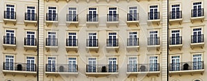 Front view of a modern residential brown brick building with balconies and Windows, close-up, pattern