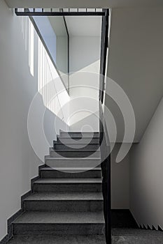 Front view of a modern stone staircase inside a newly built apartment building