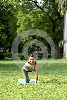 Front View Of Nice Hot Woman Performing Cow Cat Pose In Park