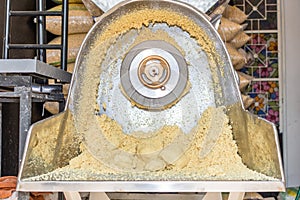 Front view of a nixtamal mill with a lot of dough inside it