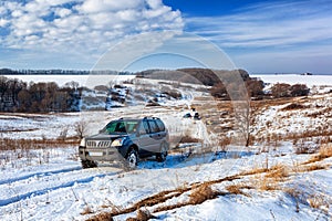 Front view of Offroad car climbing winter hill