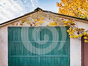 Front view of an old garage with green wooden gate