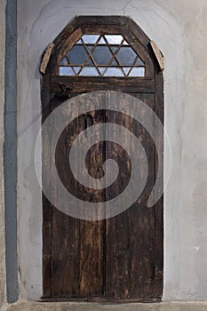 Front view of old wooden door with color glass on brick cement wall