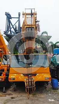 Front view old yellow telescopic mobile crane parking at the yard