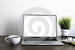 Front view of open laptop computer notebook with blank monitor white screen display on work table desk.