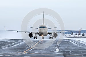Front view of the passenger airliner taxiing on taxiway in snowy winter day