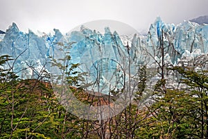 Front view of Perito Moreno Glacier, in El Calafate, Argentina, against a grey and cloudy sky.