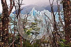 Front view of Perito Moreno Glacier, in El Calafate, Argentina, against a grey and cloudy sky.