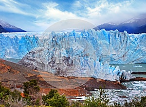 Front view of Perito Moreno Glacier, in El Calafate, Argentina, against a grey sky.
