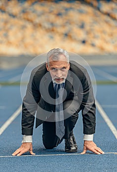 Front view photo of mature businessman standing on race track